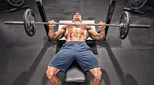 Man performing a barbell bench press with the bar at his chest